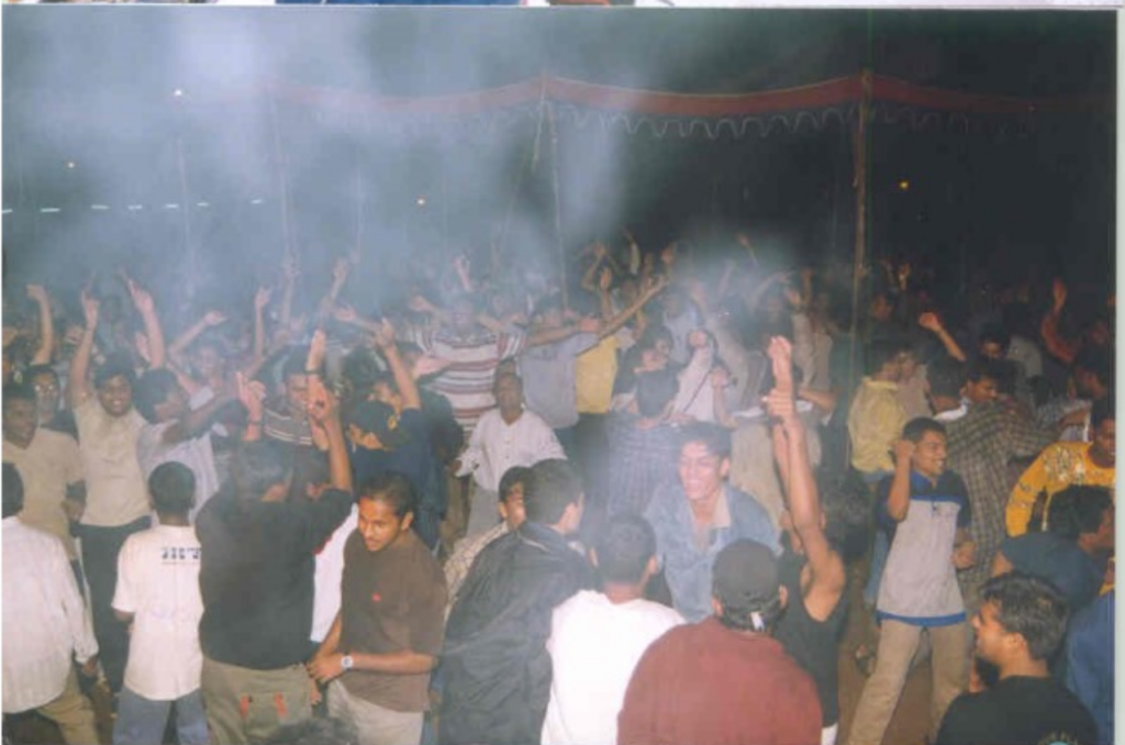 A picture of a crowd of young adults partying, with white smoke giving the scene a hazy view.